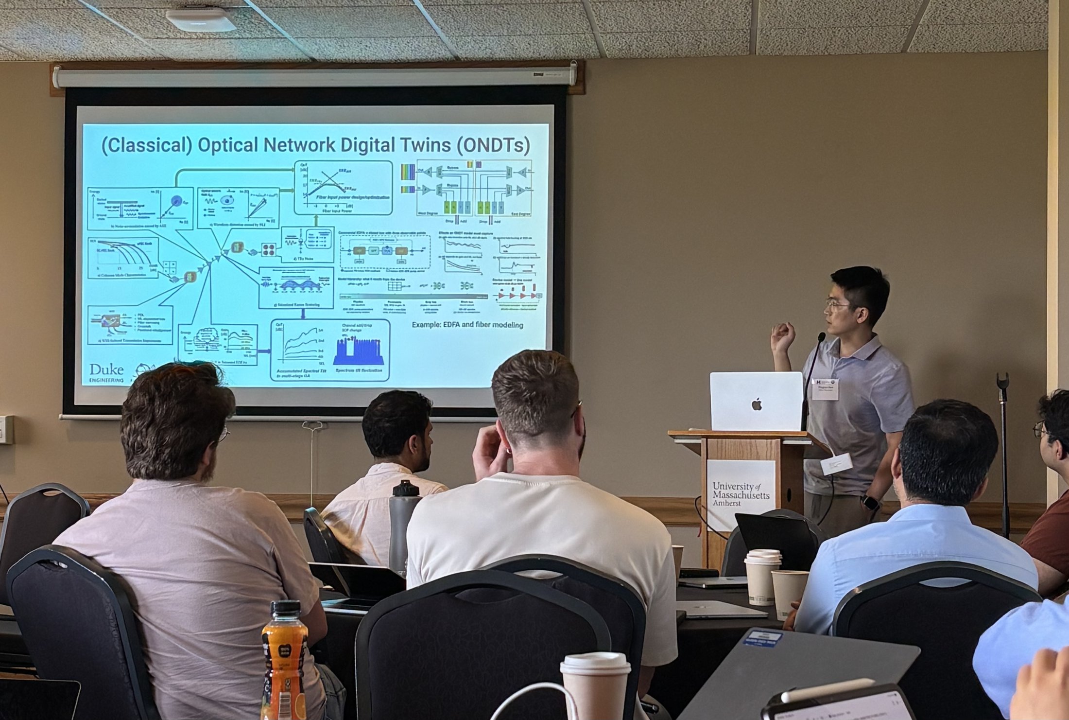 Presenter discussing optical network digital twins with workshop attendees.